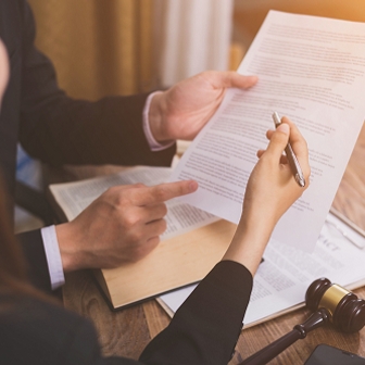 Dos personas revisando un documento legal   Cuadro de texto 